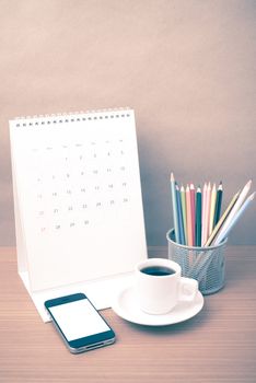 coffee,phone,calendar and color pencil on wood table background vintage style