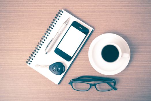 coffee,phone,notepad,eyeglasses and car key on wood table background vintage style