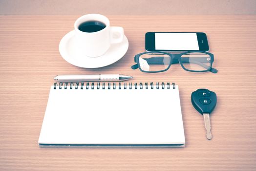 coffee,phone,notepad,eyeglasses and car key on wood table background vintage style