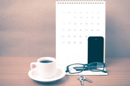 coffee,phone,eyeglasses,calendar and key on wood table background vintage style