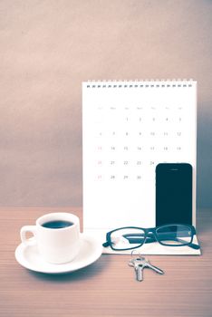 coffee,phone,eyeglasses,calendar and key on wood table background vintage style