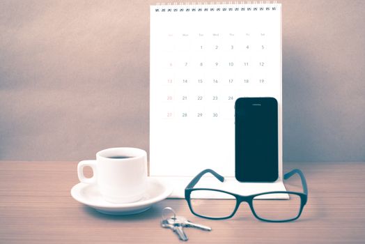coffee,phone,eyeglasses,calendar and key on wood table background vintage style