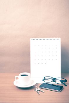 coffee,phone,eyeglasses,calendar and key on wood table background vintage style