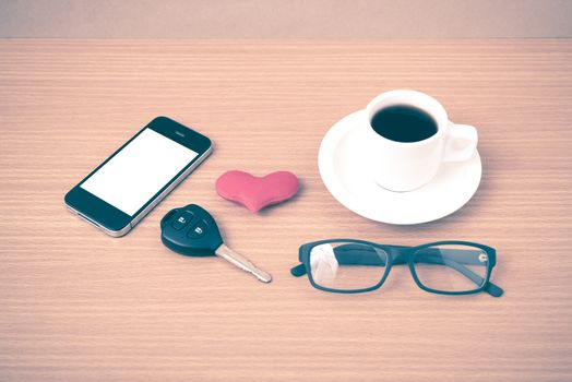 coffee,phone,eyeglasses and car key on wood table background vintage style