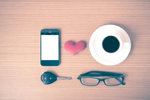 coffee,phone,eyeglasses and car key on wood table background vintage style