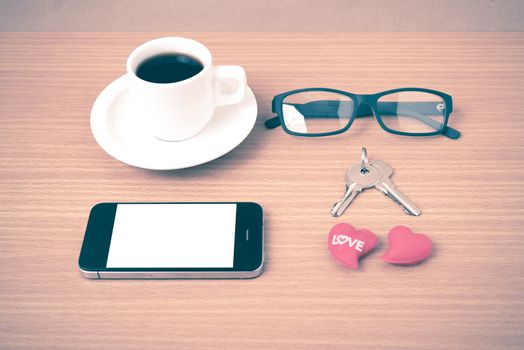 coffee,phone,eyeglasses and key on wood table background vintage style