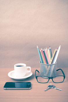 coffee,phone,eyeglasses,color pencil and key on wood table background vintage style
