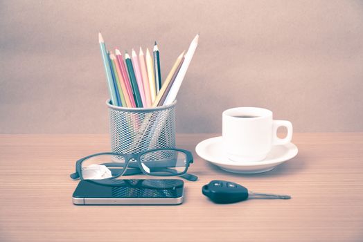 coffee,phone,eyeglasses,color pencil and car key on wood table background vintage style