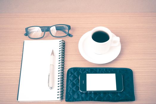 coffee,phone,eyeglasses,notepad and wallet on wood table background vintage style