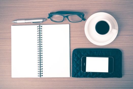 coffee,phone,eyeglasses,notepad and wallet on wood table background vintage style