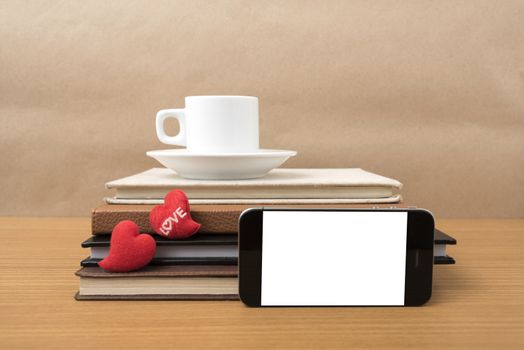 coffee,phone,stack of book and heart on wood table background