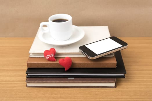 coffee,phone,stack of book and heart on wood table background