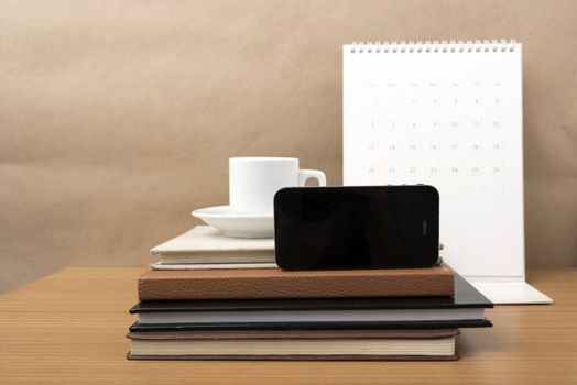 coffee,phone,stack of book and calendar on wood table background