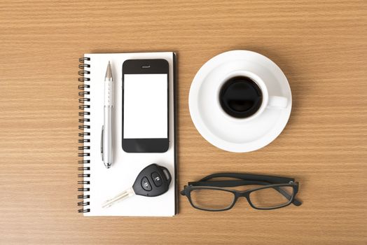 coffee,phone,notepad,eyeglasses and car key on wood table background
