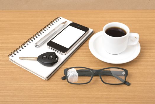 coffee,phone,notepad,eyeglasses and car key on wood table background