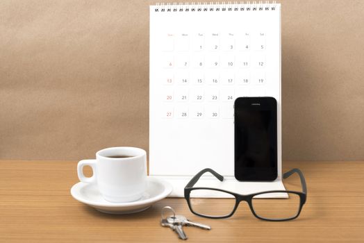 coffee,phone,eyeglasses,calendar and key on wood table background