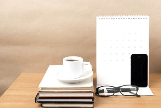 coffee,phone,eyeglasses,stack of book and calendar on wood table background