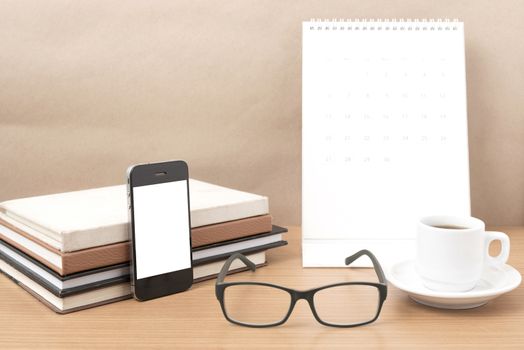 coffee,phone,eyeglasses,stack of book and calendar on wood table background