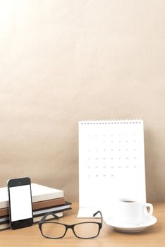 coffee,phone,eyeglasses,stack of book and calendar on wood table background