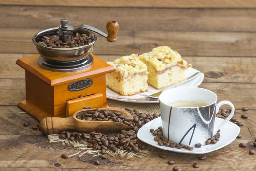 cup of coffee, apple cake and coffee grinder on wooden background