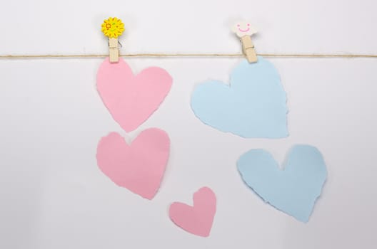 Beautiful paper hearts connected with a rope on white paper background.