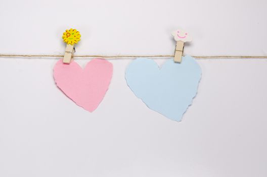 Beautiful paper hearts connected with a rope on white paper background.