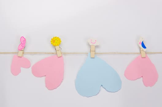 Beautiful paper hearts connected with a rope on white paper background.