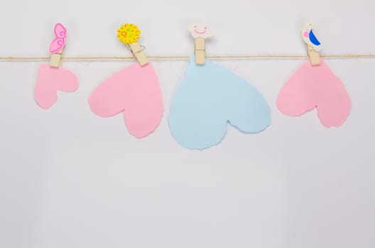 Beautiful paper hearts connected with a rope on white paper background.