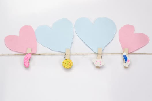 Beautiful paper hearts connected with a rope on white paper background