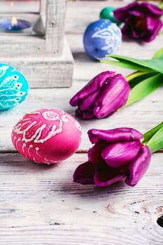 Decorated with painted Easter eggs and flowers on a light background