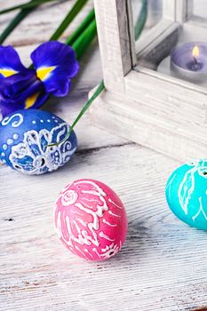 Decorated with painted Easter eggs and flowers on a light background