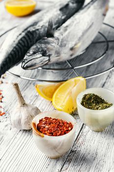 Thawed fresh fish mackerel with spices and marinade with lemon.Photograph high key
