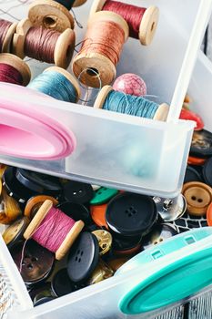 Two plastic box with sewing threads and buttons.