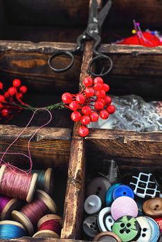 set for needlework from buttons,thread and needles within the cells in the wooden box
