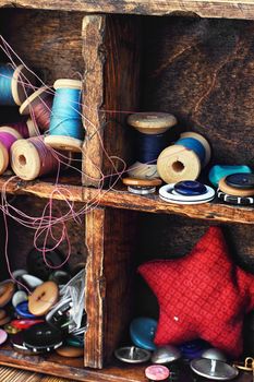 set for needlework from buttons,thread and needles within the cells in the wooden box