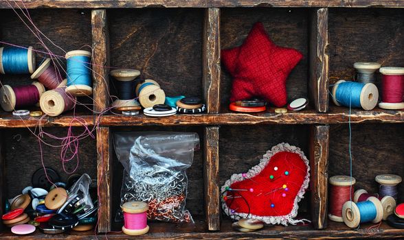 set for needlework from buttons,thread and needles within the cells in the wooden box