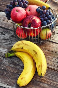 Ripe bananas and the apples in the barrel braided iron rods