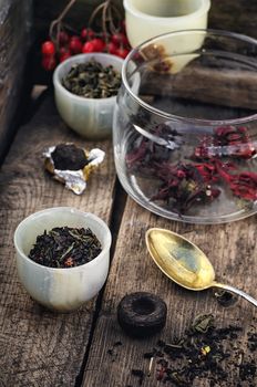 small cup with tea brewing in the background spoons and viburnum