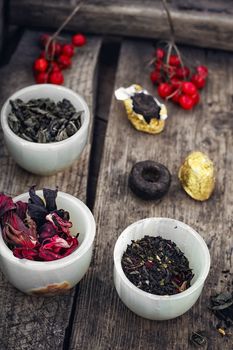 small cup with tea brewing in the background spoons and viburnum