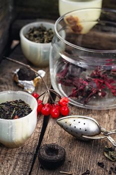trendy cup with tea brewing in the background spoons and viburnum