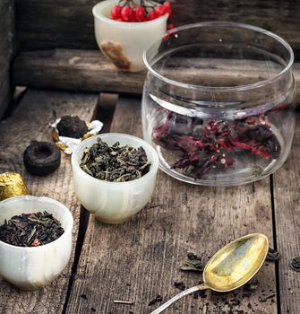 small cup with tea brewing in the background spoons and viburnum