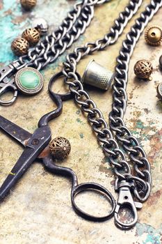 Metal beads,buttons,chain and scissors on retro background