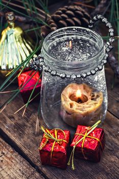 Christmas candle in the spilled wax in stylish glass candle holder