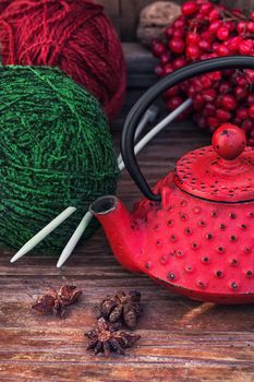 Red and green ball of wool for knitting and red kettle.