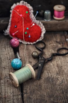 Old scissors,spools of thread,buttons and beads on wooden table