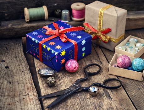 Old scissors,spools of thread,buttons and beads on wooden table