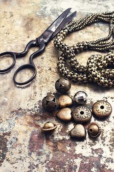 Set of beads and chains for crafts located on metal background