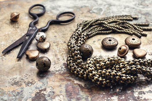 Set of beads and chains for crafts located on metal background