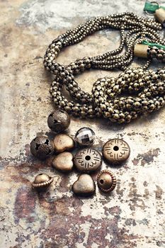 Set of beads and chains for crafts located on metal background