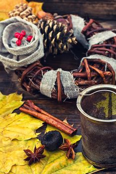 Woven autumn wreath amid fallen maple leaves